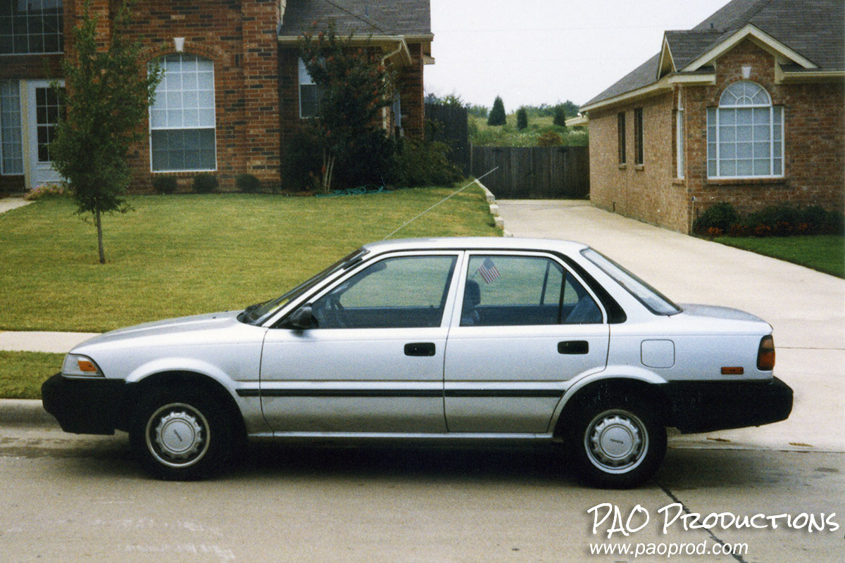 Toyota Corolla parked in front of house, summer 1995